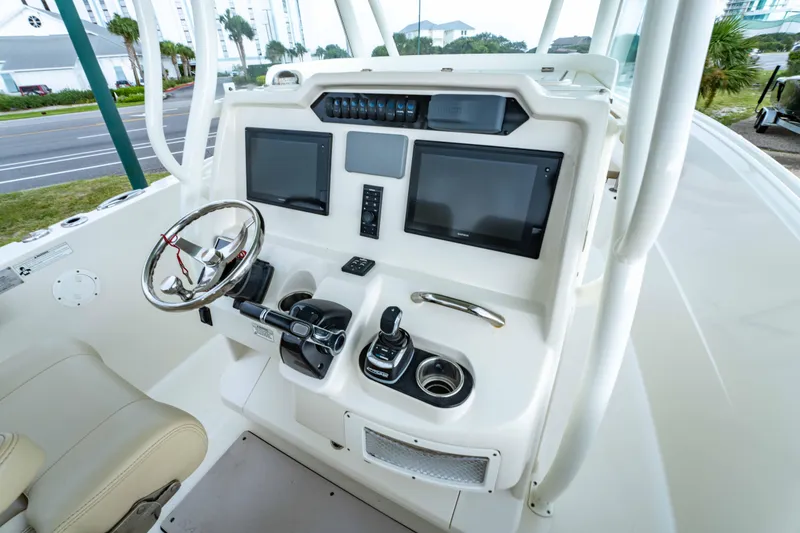Slide: The Image of 2018 Sailfish 290 CC boat dashboard with dual screens and steering wheel. - 27