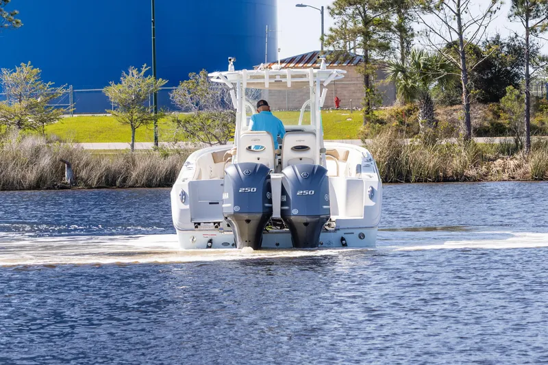 Slide: The Image of 2018 Sailfish 290 CC boat with dual engines cruising on a calm waterway. - 3
