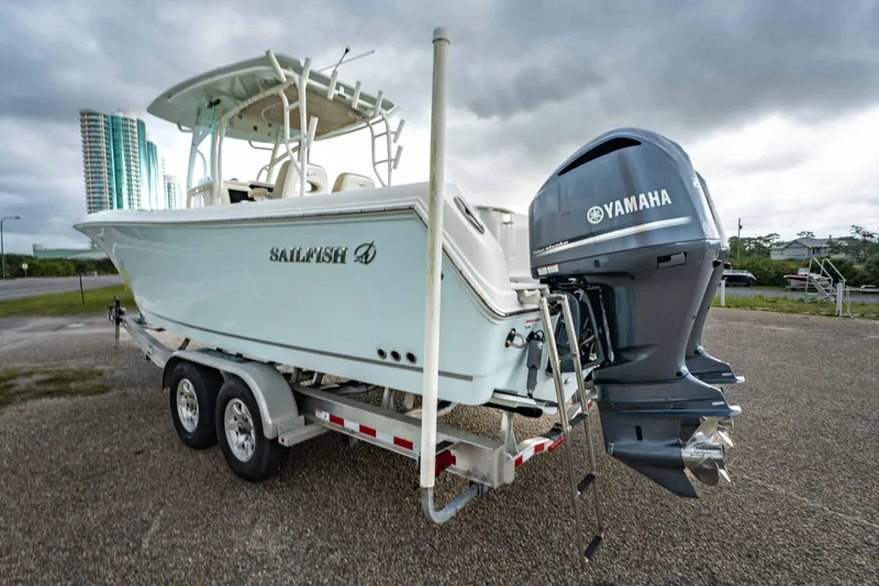 Slide: The Image of 2018 Sailfish 290 CC boat on trailer with Yamaha outboard motor, parked outdoors. - 30
