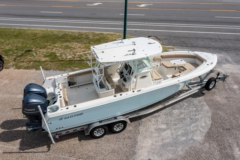 Slide: The Image of 2018 Sailfish 290 CC boat on trailer, dual engines, parked near road. - 33
