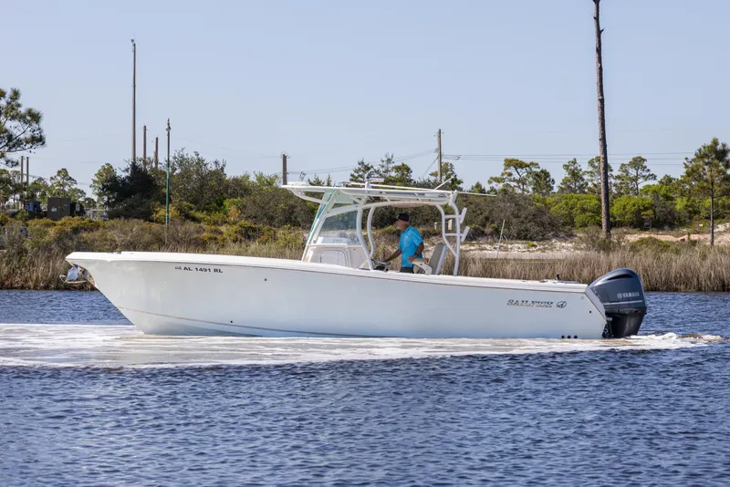 Slide: The Image of 2018 Sailfish 290 CC boat cruising on a calm waterway with scenic background. - 4