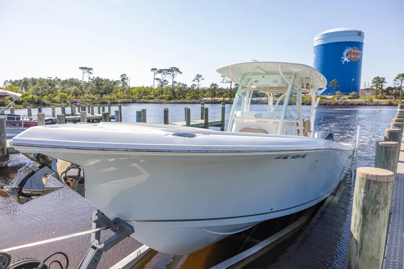 Slide: The Image of 2018 Sailfish 290 CC boat docked near a blue water tower. - 8