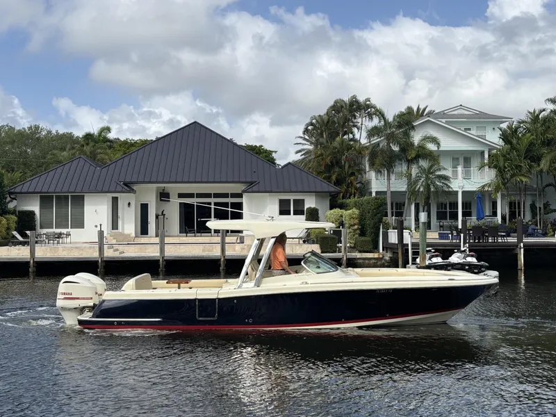 Slide: The Image of 2019 Chris-Craft Calypso 30 boat cruising near waterfront homes. - 1