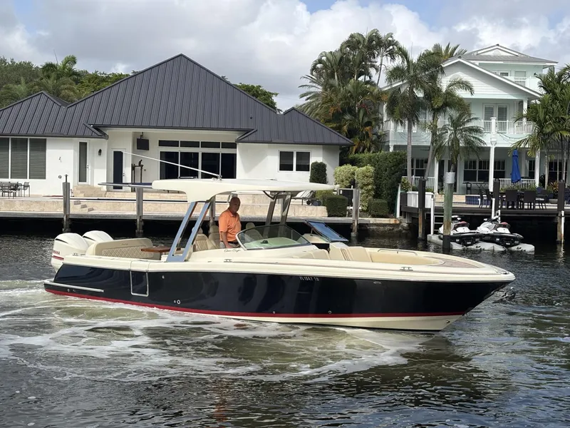 Slide: The Image of 2019 Chris-Craft Calypso 30 boat cruising near waterfront homes. - 11