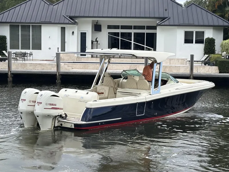 Slide: The Image of 2019 Chris-Craft Calypso 30 boat with dual Yamaha engines near a modern waterfront home. - 12
