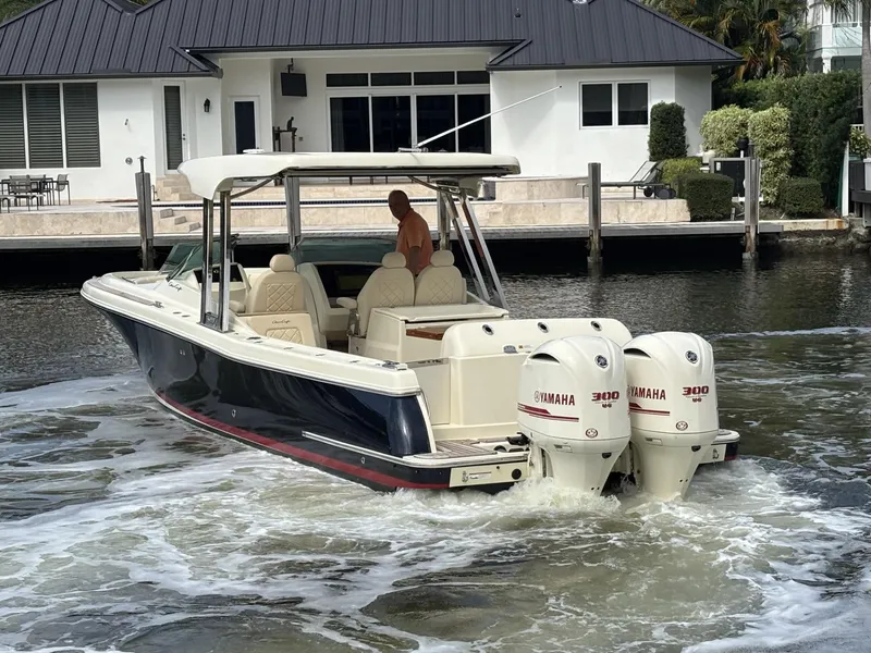 Slide: The Image of 2019 Chris-Craft Calypso 30 boat with twin Yamaha engines near a waterfront house. - 14
