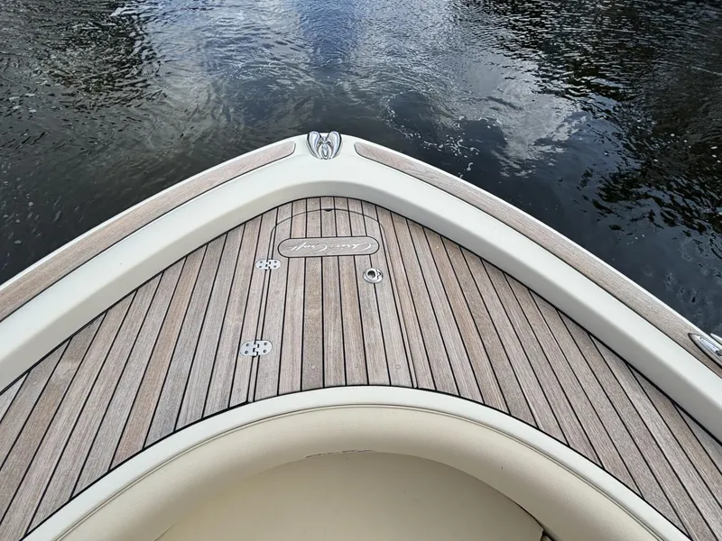 Slide: The Image of Bow of 2019 Chris-Craft Calypso 30 with teak decking on calm water. - 5