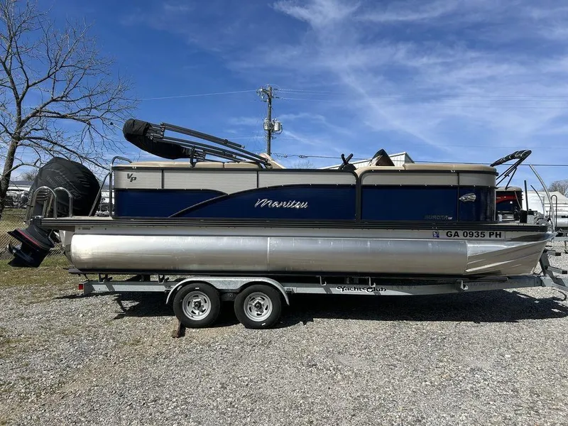 Slide: The Image of 2022 Manitou 21 Aurora LE RF VP II pontoon boat on trailer, parked outdoors. - 1