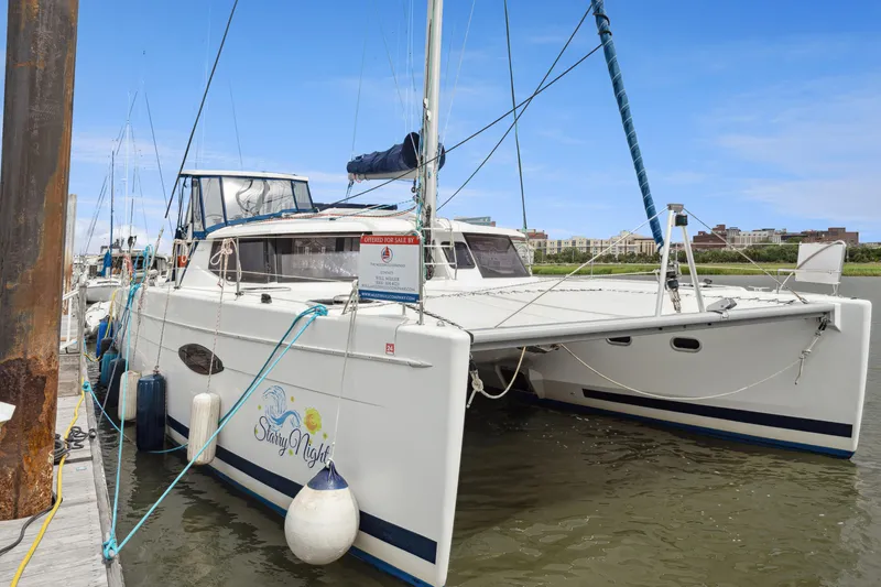 Slide: The Image of 2014 Fountaine Pajot Helia 44 catamaran docked, featuring sleek design and spacious deck. - 14