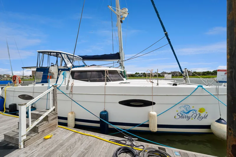 Slide: The Image of 2014 Fountaine Pajot Helia 44 catamaran docked, named "Starry Night," under clear blue sky. - 15
