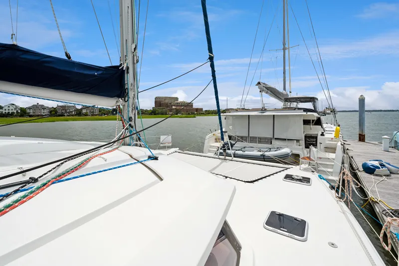 Slide: The Image of 2014 Fountaine Pajot Helia 44 catamaran docked at marina, clear sky, waterfront homes. - 16