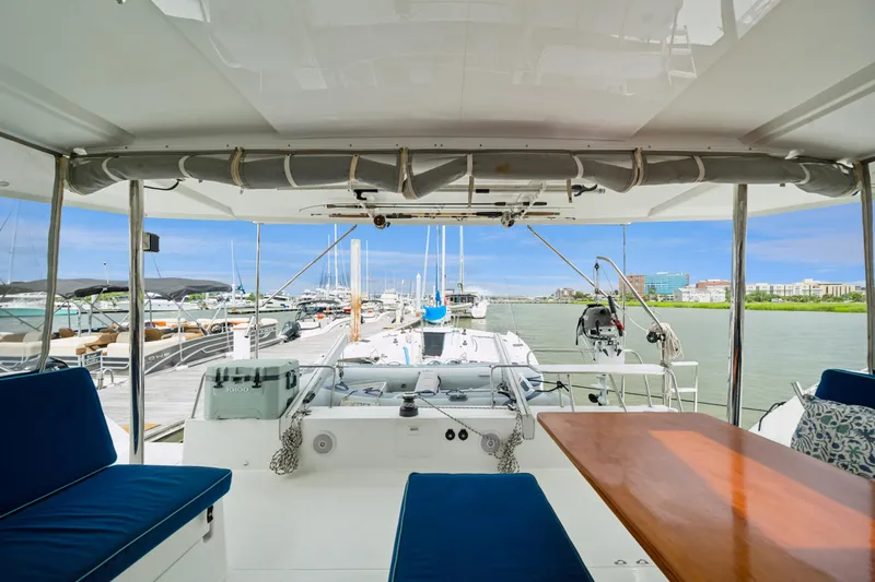 Slide: The Image of 2014 Fountaine Pajot Helia 44 catamaran docked at marina, featuring spacious seating and table. - 26
