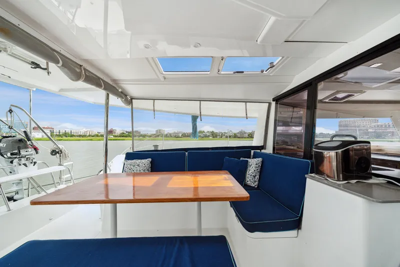 Slide: The Image of Interior of 2014 Fountaine Pajot Helia 44 catamaran with blue seating and wooden table. - 27