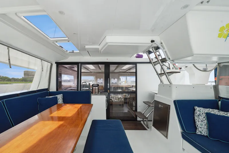 Slide: The Image of Interior of 2014 Fountaine Pajot Helia 44 catamaran with blue seating and wooden table. - 28