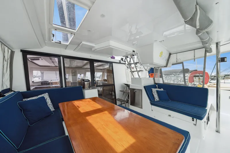Slide: The Image of 2014 Fountaine Pajot Helia 44 catamaran interior with blue seating and wooden table. - 29