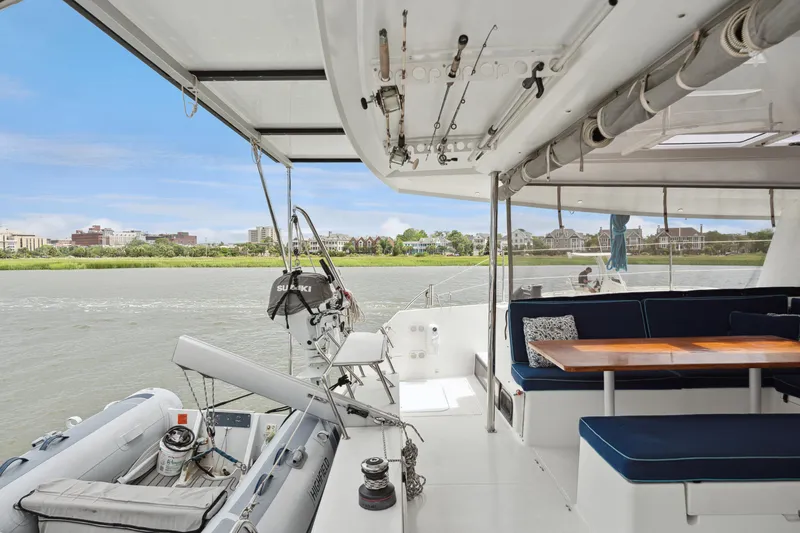 Slide: The Image of 2014 Fountaine Pajot Helia 44 catamaran with outdoor seating and scenic river view. - 32