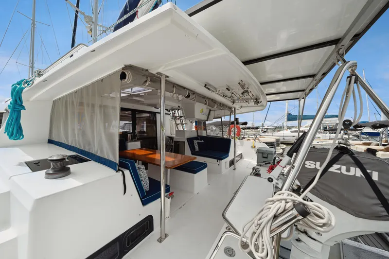Slide: The Image of 2014 Fountaine Pajot Helia 44 catamaran with spacious deck and seating area in marina. - 34