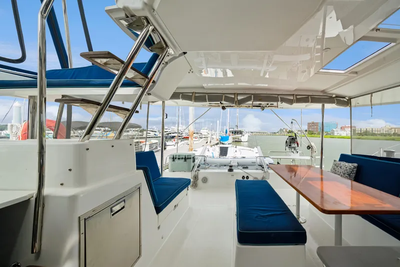 Slide: The Image of Spacious deck of 2014 Fountaine Pajot Helia 44 catamaran with blue seating and wooden table. - 35