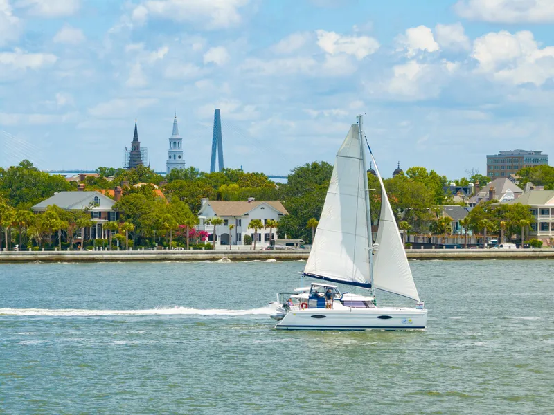 Slide: The Image of Sailing catamaran Fountaine Pajot Helia 44, 2014, cruising near a scenic waterfront cityscape. - 5