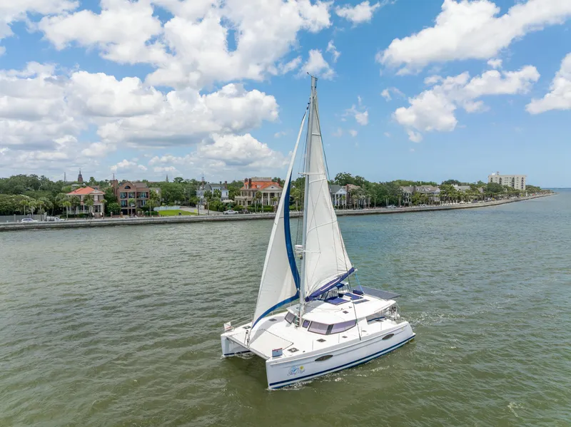 Slide: The Image of 2014 Fountaine Pajot Helia 44 catamaran sailing near a scenic coastal town. - 9