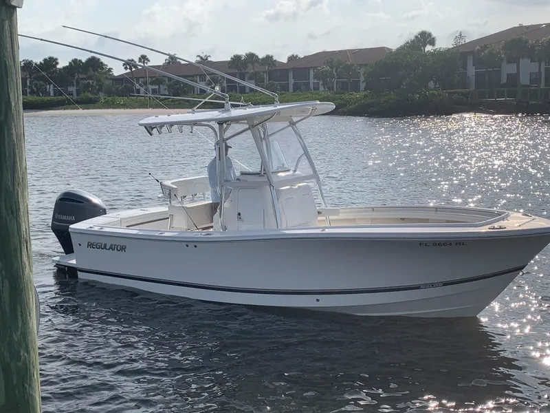 Slide: The Image of 2018 Regulator 23 Forward Seating boat on water, with Yamaha outboard motor. - 0