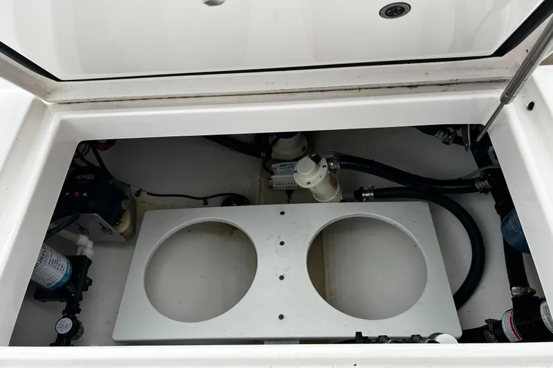 Slide: The Image of 2018 Regulator 23 Forward Seating boat storage compartment with mechanical components. - 13