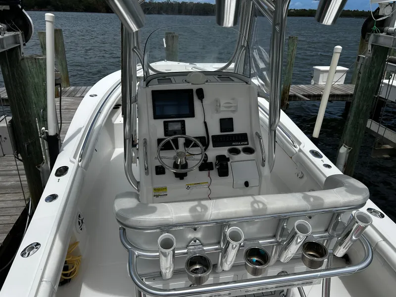 Slide: The Image of 2018 Regulator 23 Forward Seating boat at dock, featuring helm and controls. - 17