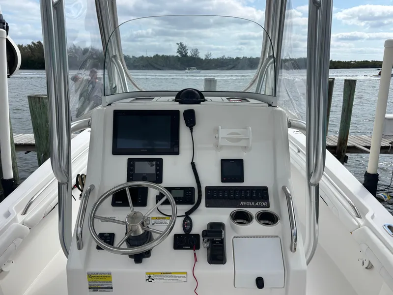 Slide: The Image of 2018 Regulator 23 Forward Seating boat console with steering wheel and navigation equipment. - 19