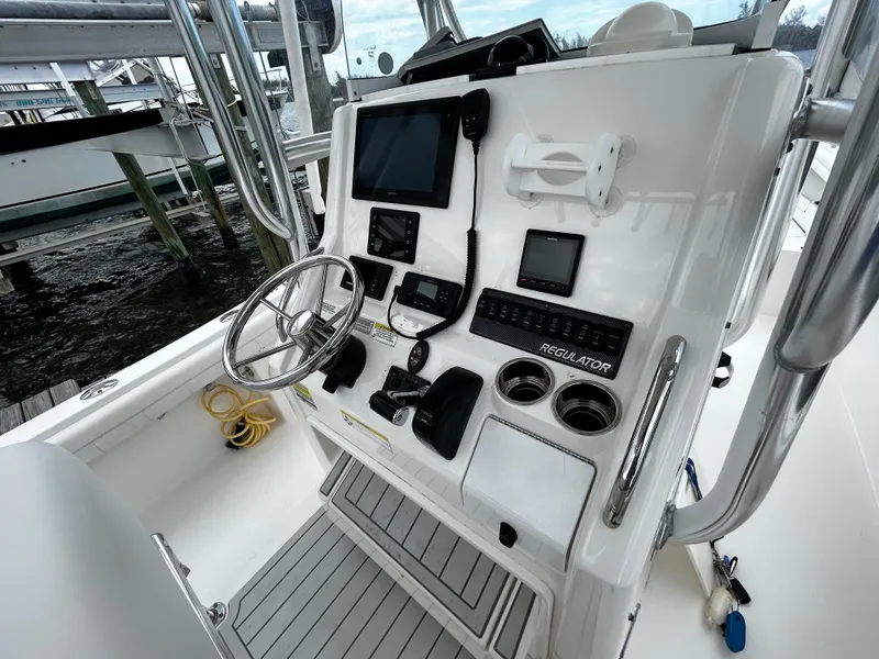 Slide: The Image of 2018 Regulator 23 Forward Seating boat console with steering wheel and navigation equipment. - 25