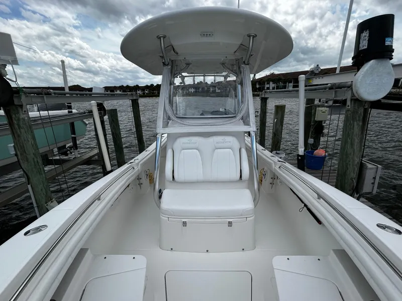 Slide: The Image of 2018 Regulator 23 Forward Seating boat docked, showcasing spacious seating and sleek design. - 27