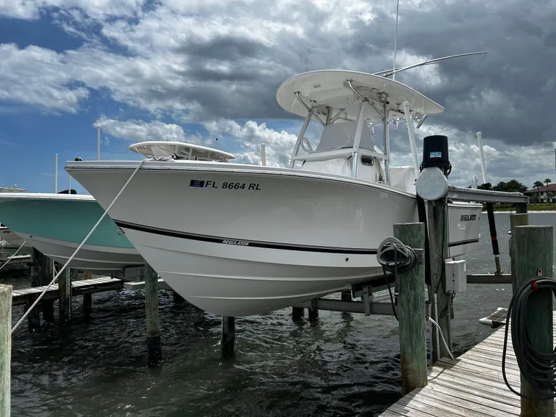 Slide: The Image of 2018 Regulator 23 Forward Seating boat docked under cloudy sky. - 3