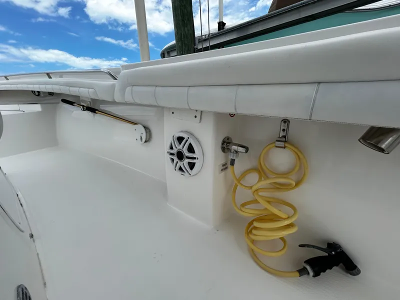 Slide: The Image of 2018 Regulator 23 Forward Seating boat deck with speaker and coiled hose under blue sky. - 33