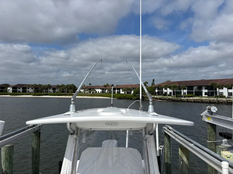 Slide: The Image of 2018 Regulator 23 Forward Seating boat docked by waterfront homes under cloudy sky. - 38