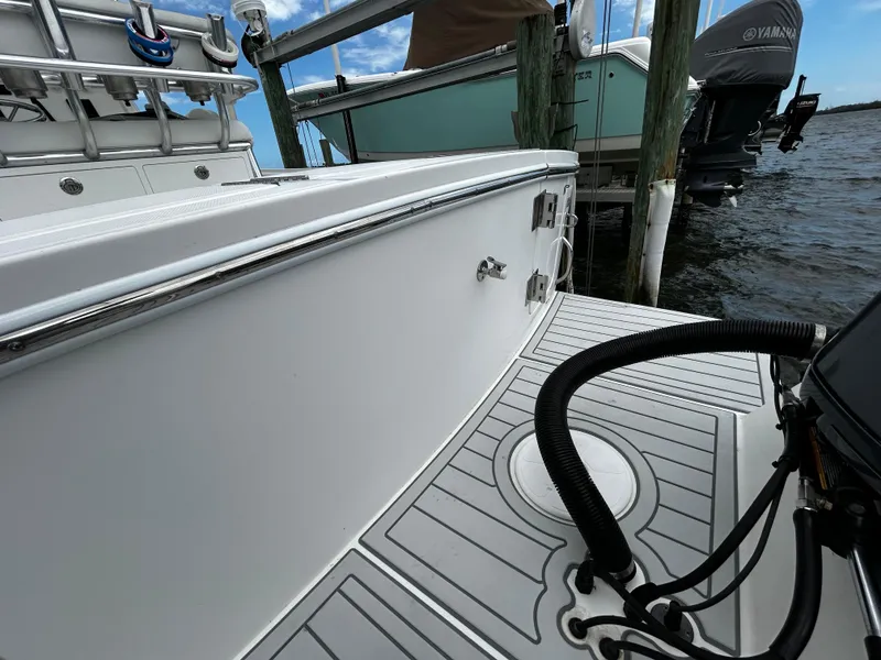 Slide: The Image of 2018 Regulator 23 Forward Seating boat docked, showcasing sleek design and modern features. - 4