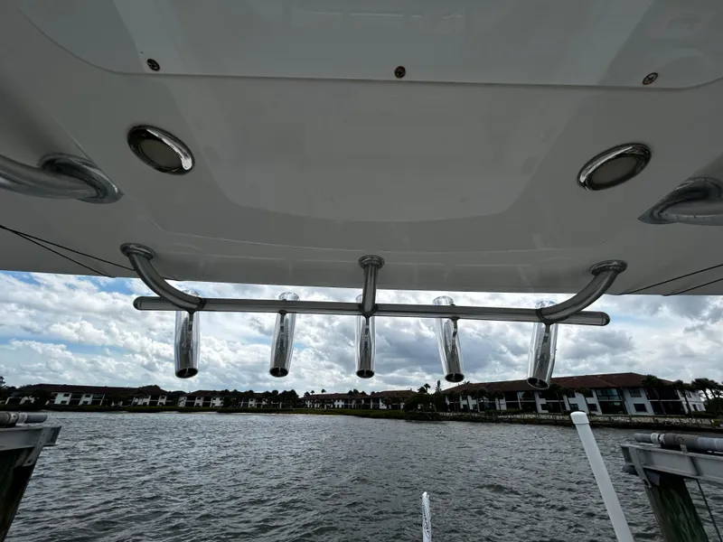 Slide: The Image of 2018 Regulator 23 Forward Seating boat with rod holders, overlooking a waterfront view. - 40