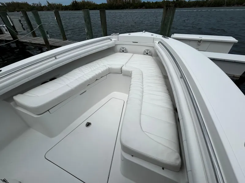 Slide: The Image of 2018 Regulator 23 Forward Seating boat with white cushioned seats, docked by the water. - 42