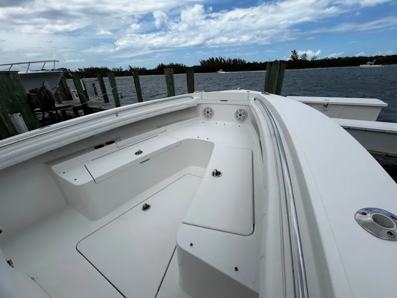 Slide: The Image of 2018 Regulator 23 Forward Seating boat docked by the water under a cloudy sky. - 43