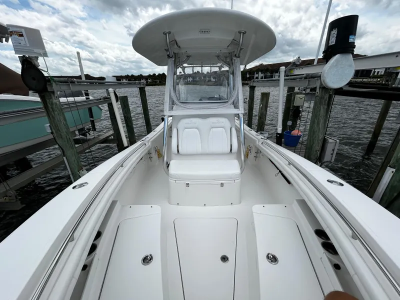 Slide: The Image of 2018 Regulator 23 Forward Seating boat docked, showcasing spacious seating and sleek design. - 48