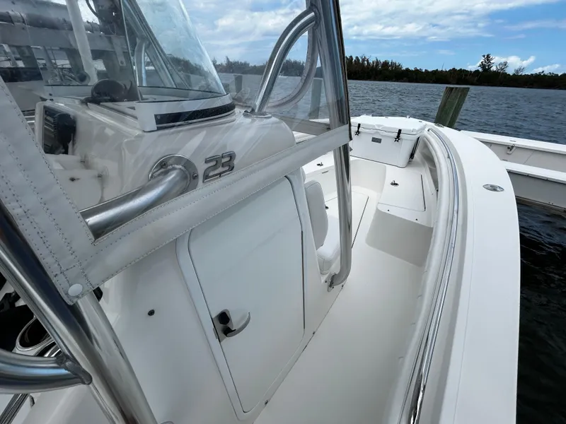 Slide: The Image of 2018 Regulator 23 Forward Seating boat on water, showcasing sleek design and spacious deck. - 49