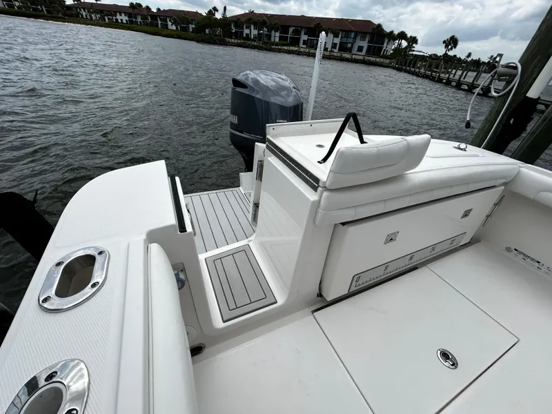 Slide: The Image of 2018 Regulator 23 Forward Seating boat, rear view, docked by waterfront homes. - 7