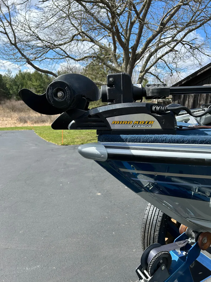 Slide: The Image of 2003 Lund 1800 Fisherman boat with Minn Kota Terrova motor, parked outdoors. - 7