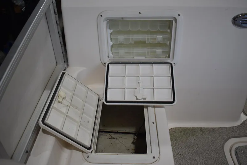Slide: The Image of Storage compartments on a 2006 Hurricane FunDeck 228 RE boat, featuring open hatches. - 17