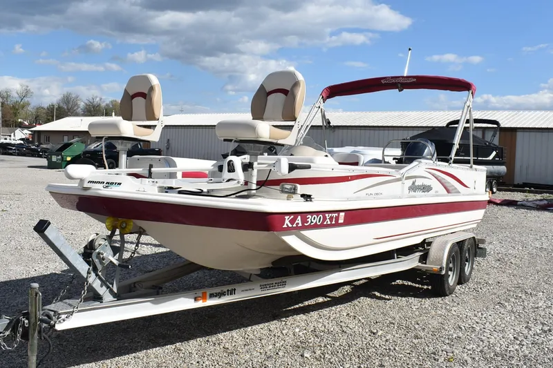 Slide: The Image of 2006 Hurricane FunDeck 228 RE boat on trailer, red and white, parked outdoors. - 3