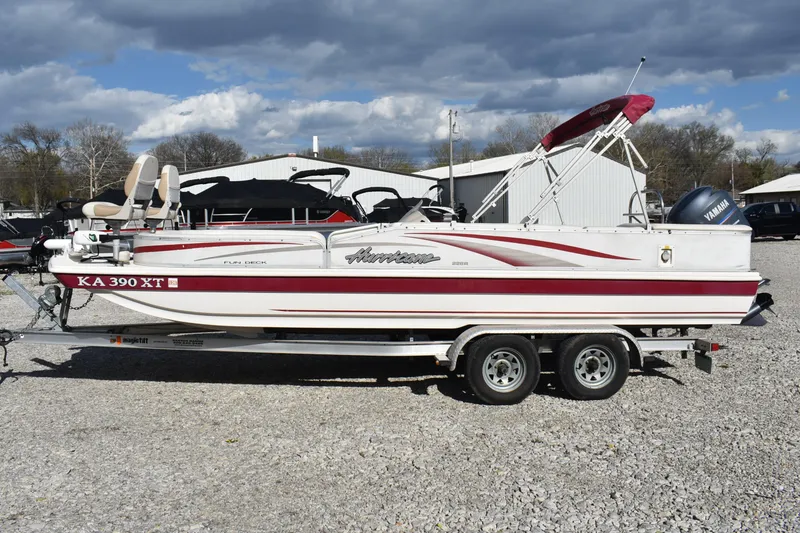 Slide: The Image of 2006 Hurricane FunDeck 228 RE boat on trailer, parked outdoors under cloudy sky. - 4