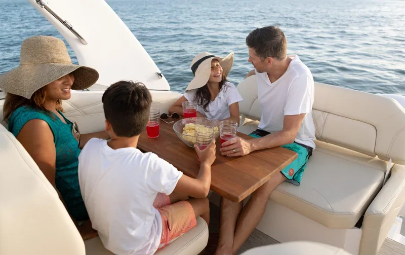Slide: The Image of Family enjoying a day on a 2022 Regal 26 XO boat, sharing snacks and drinks. - 18