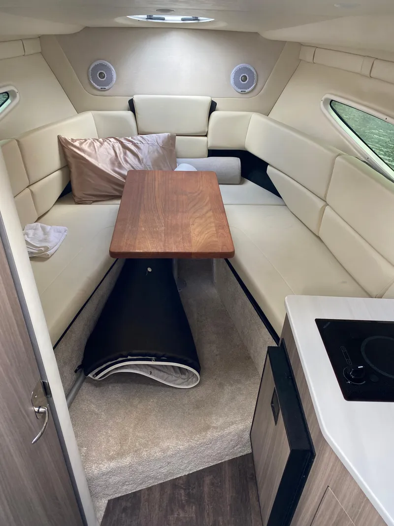 Slide: The Image of 2022 Regal 26 XO cabin interior with seating, table, and kitchenette. - 20
