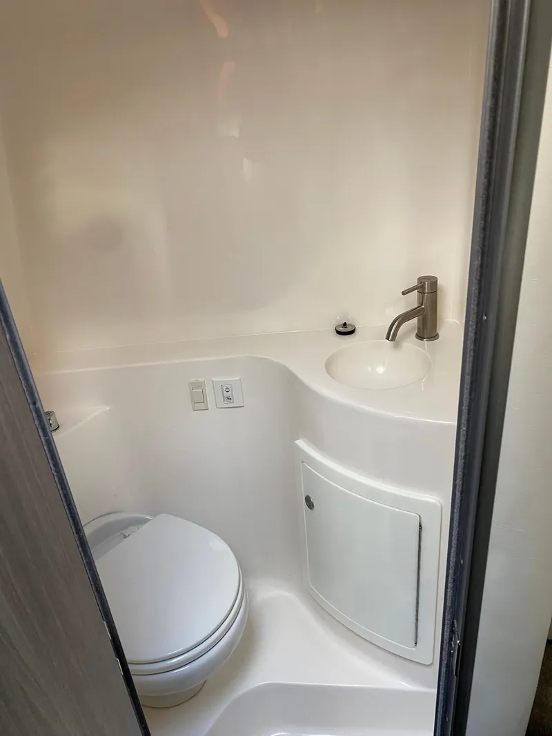 Slide: The Image of 2022 Regal 26 XO boat bathroom with compact sink and toilet. - 28