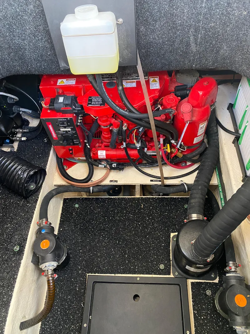 Slide: The Image of Engine compartment of a 2022 Regal 26 XO boat, featuring a red engine and various components. - 29