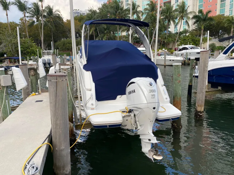 Slide: The Image of 2022 Regal 26 XO boat docked with Yamaha 300 engine, covered in blue tarp. - 5