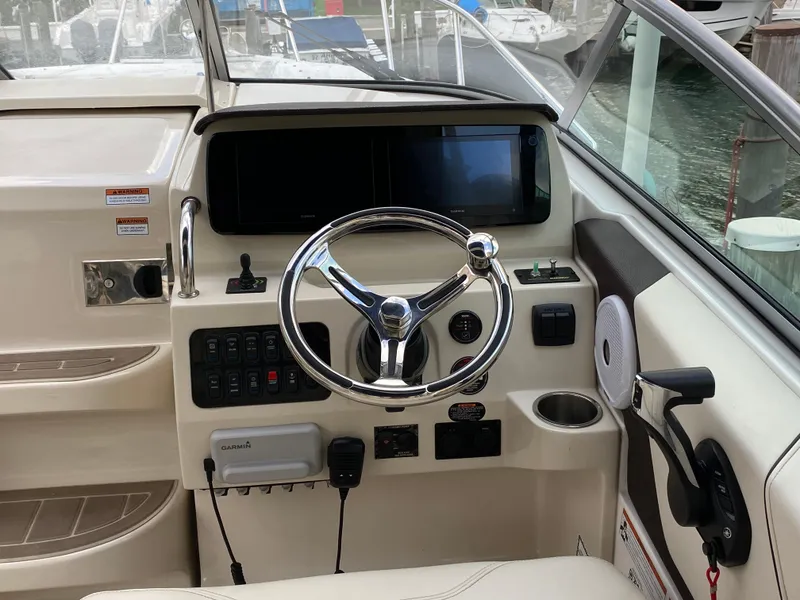 Slide: The Image of 2022 Regal 26 XO boat helm with steering wheel and control panel. - 8